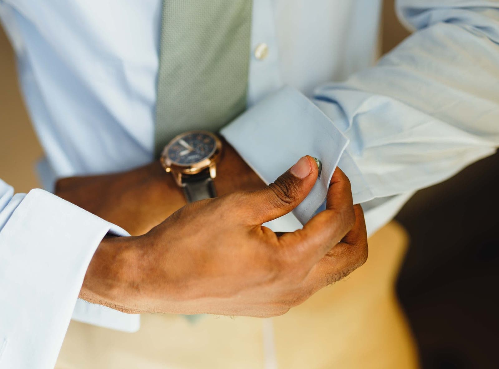 A wristwatch showing beneath a formal shirt cuff