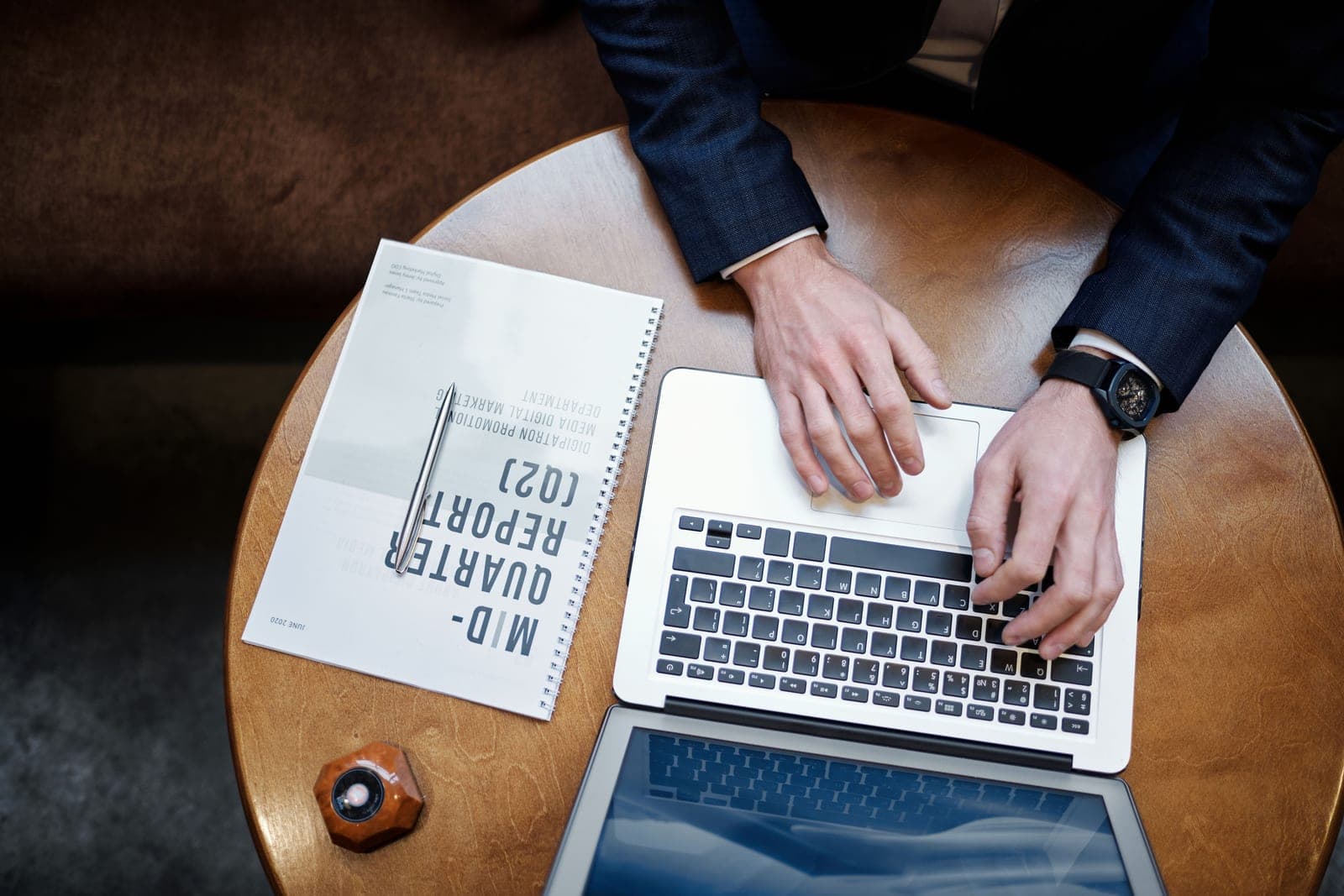 A wristwatch on a desk beside paperwork