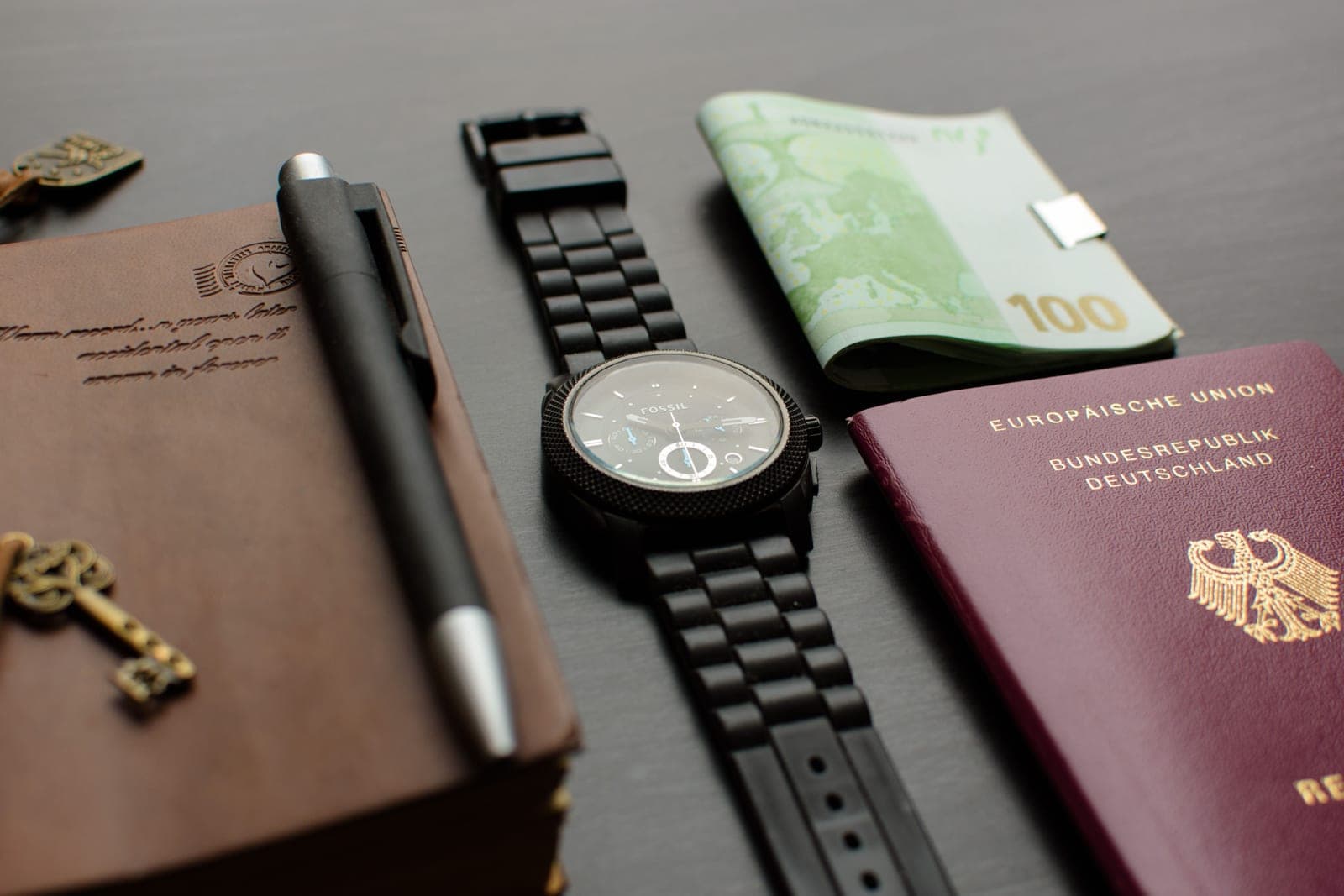 A passport and a wristwatch on a desk