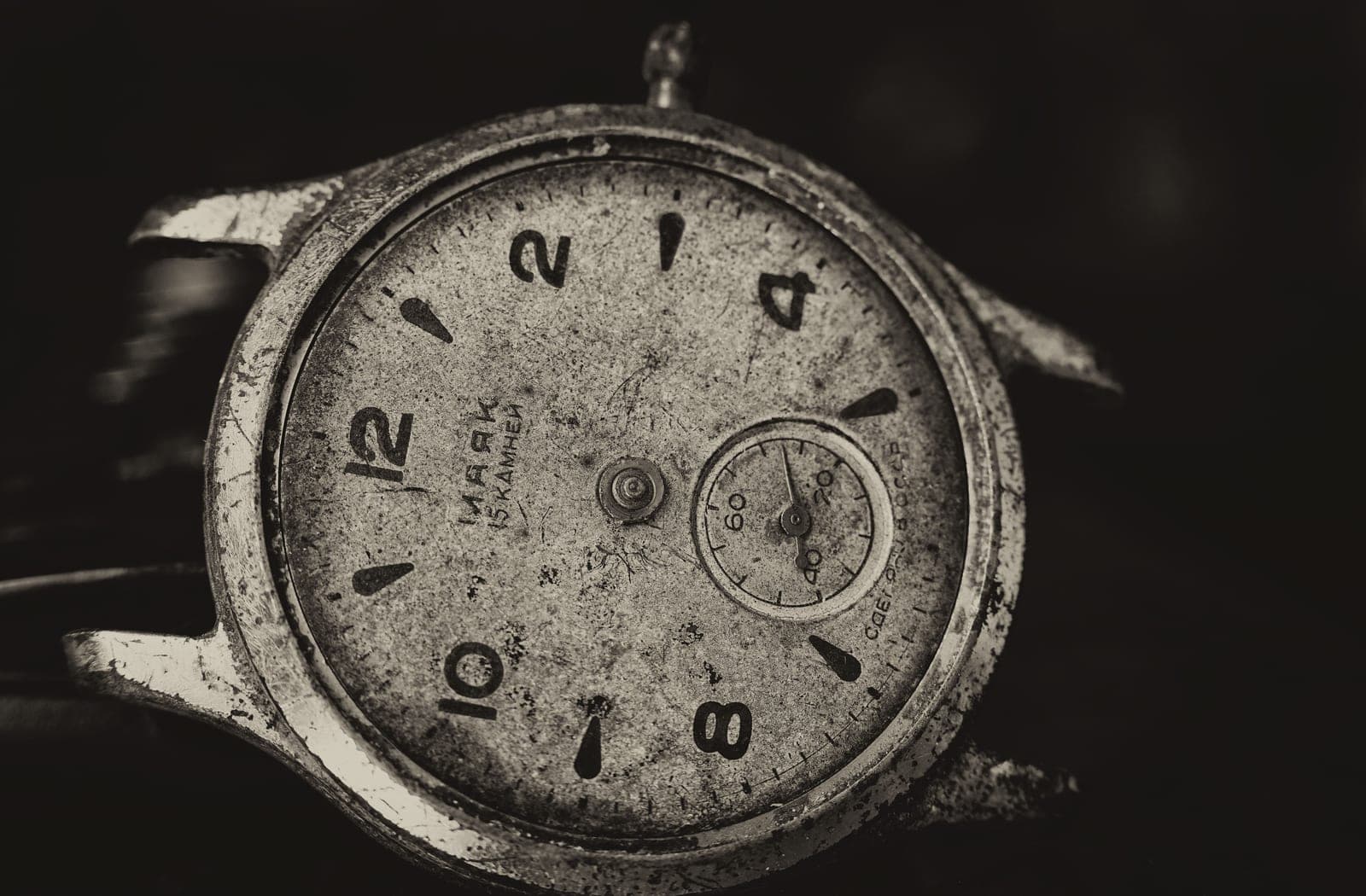 An old, worn wristwatch with a scratched case