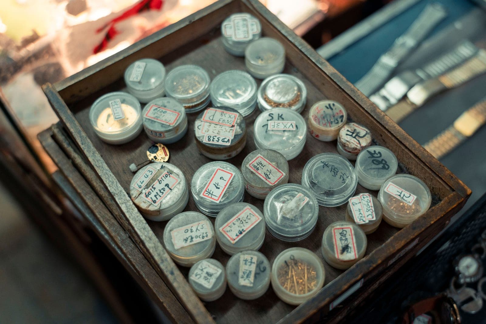 Watch parts laid out in a tray on a workbench